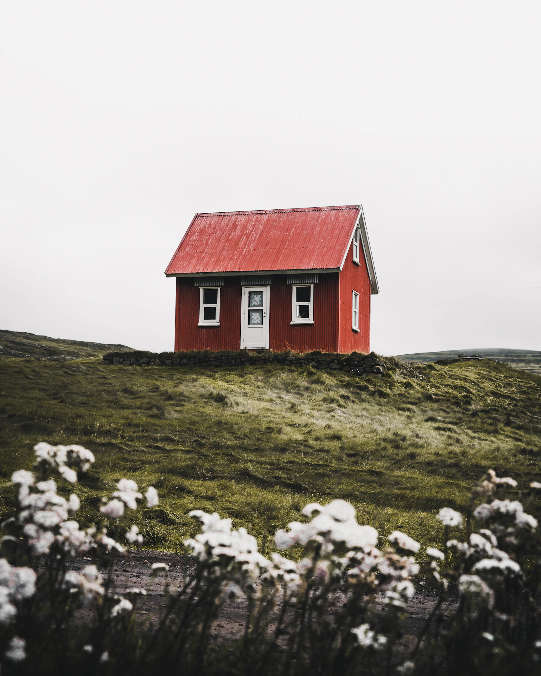 Small red cabin with a steep corrugated roof